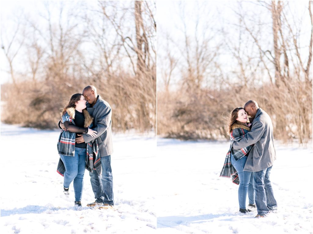 engaged couple dancing and snuggling in the snow during engagement session at binder park