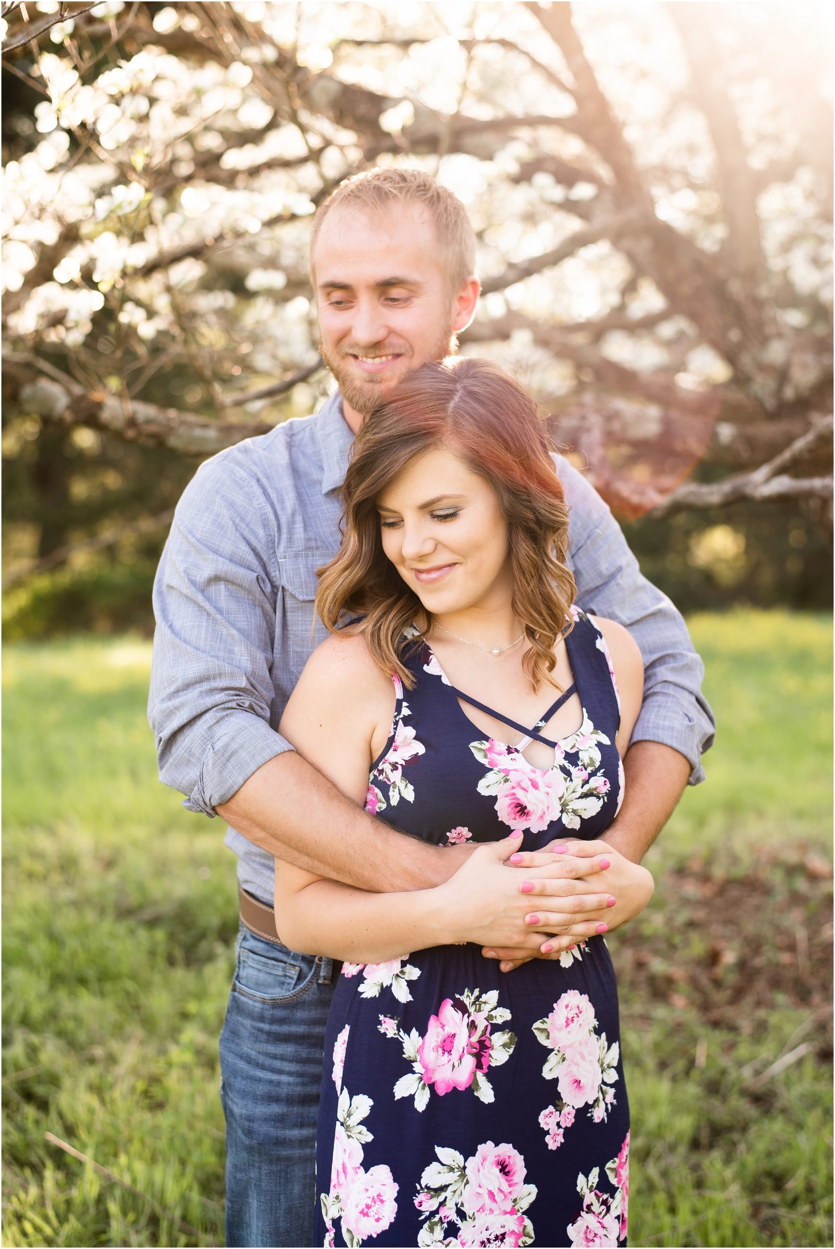 couple standing under large tree posing for portraits