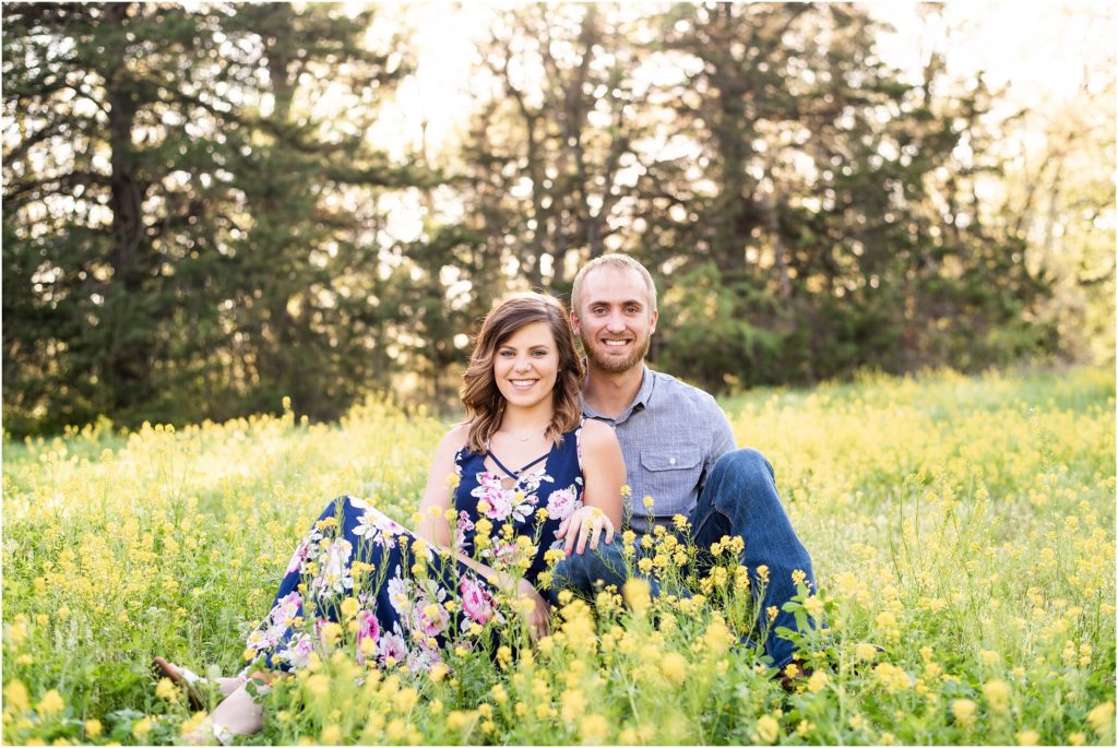 couple sitting together on yellow wildflower field for Linn, MO couples portraits