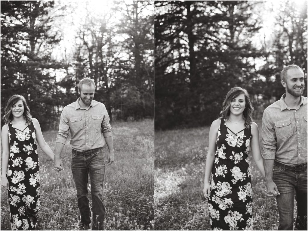 black and white image of couple walking in field for photos