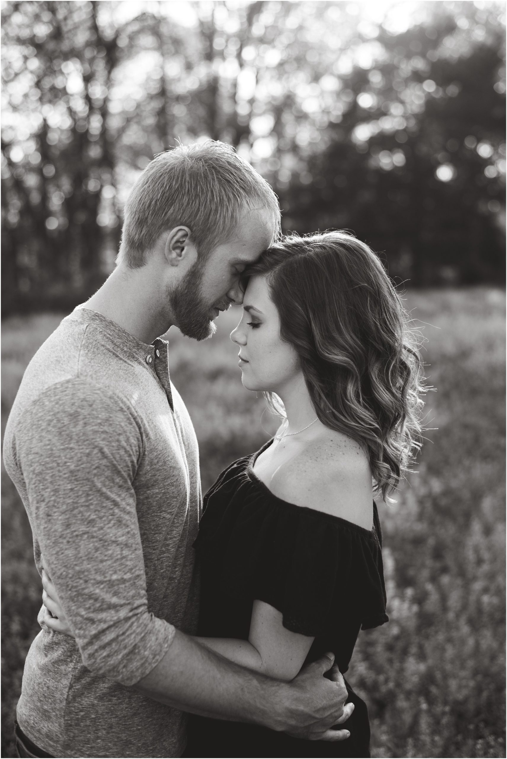 black and white image of couple touching foreheads with eyes closed for Linn, MO couples portraits