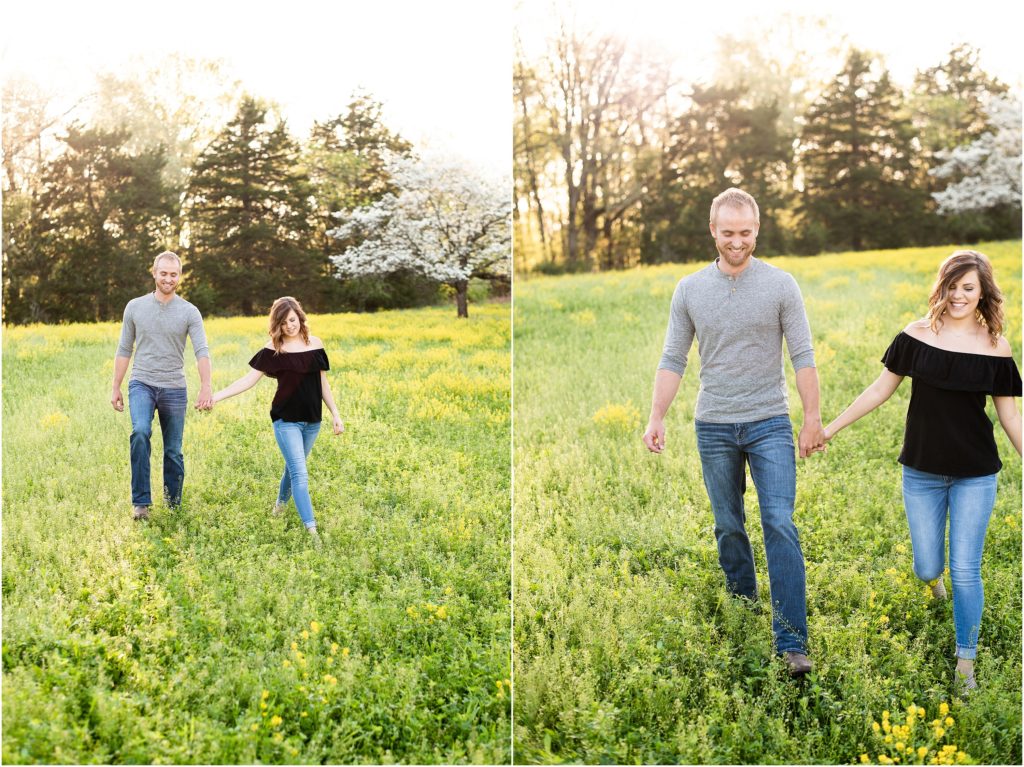 couple walking together in yellow wildflower field laughing and smiling for photos