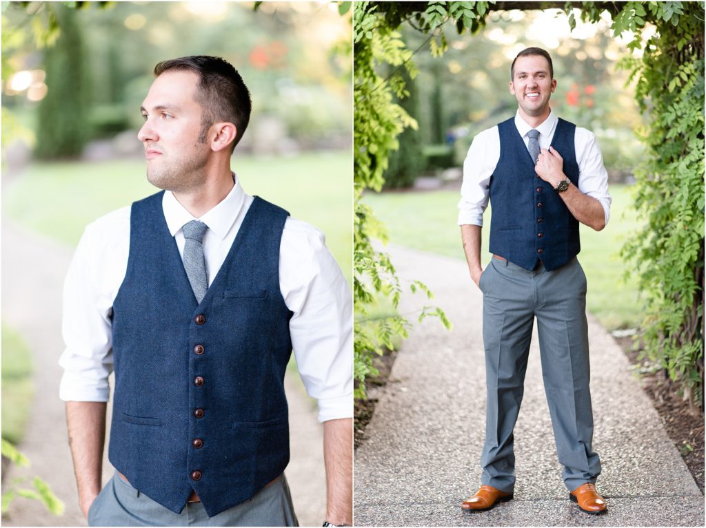groom wearing blue button up vest and posing under greenery at shelter gardens