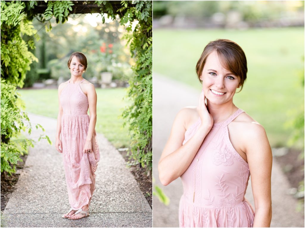 image of girl in pink dress under fern covered arbor during engagement session