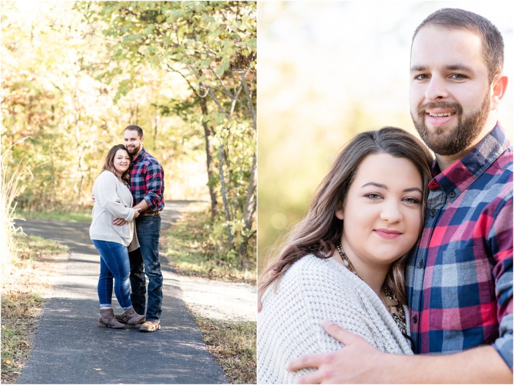 couple hugging each other on sidewalk under trees for engagement session
