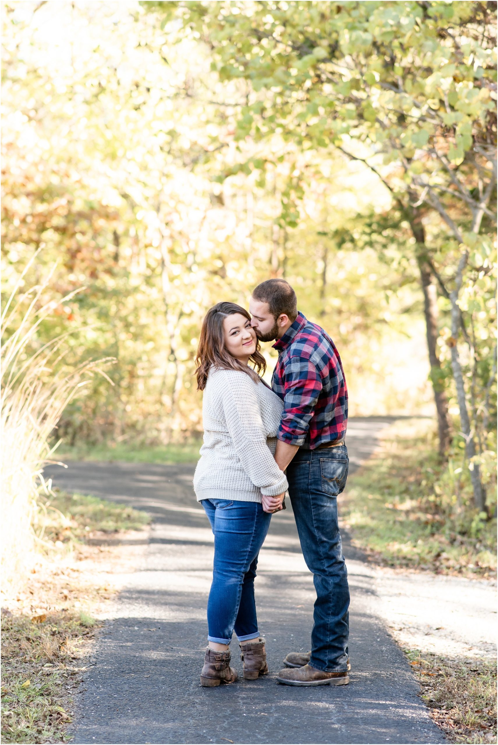 couple kissing on path under trees for runge nature center engagement session
