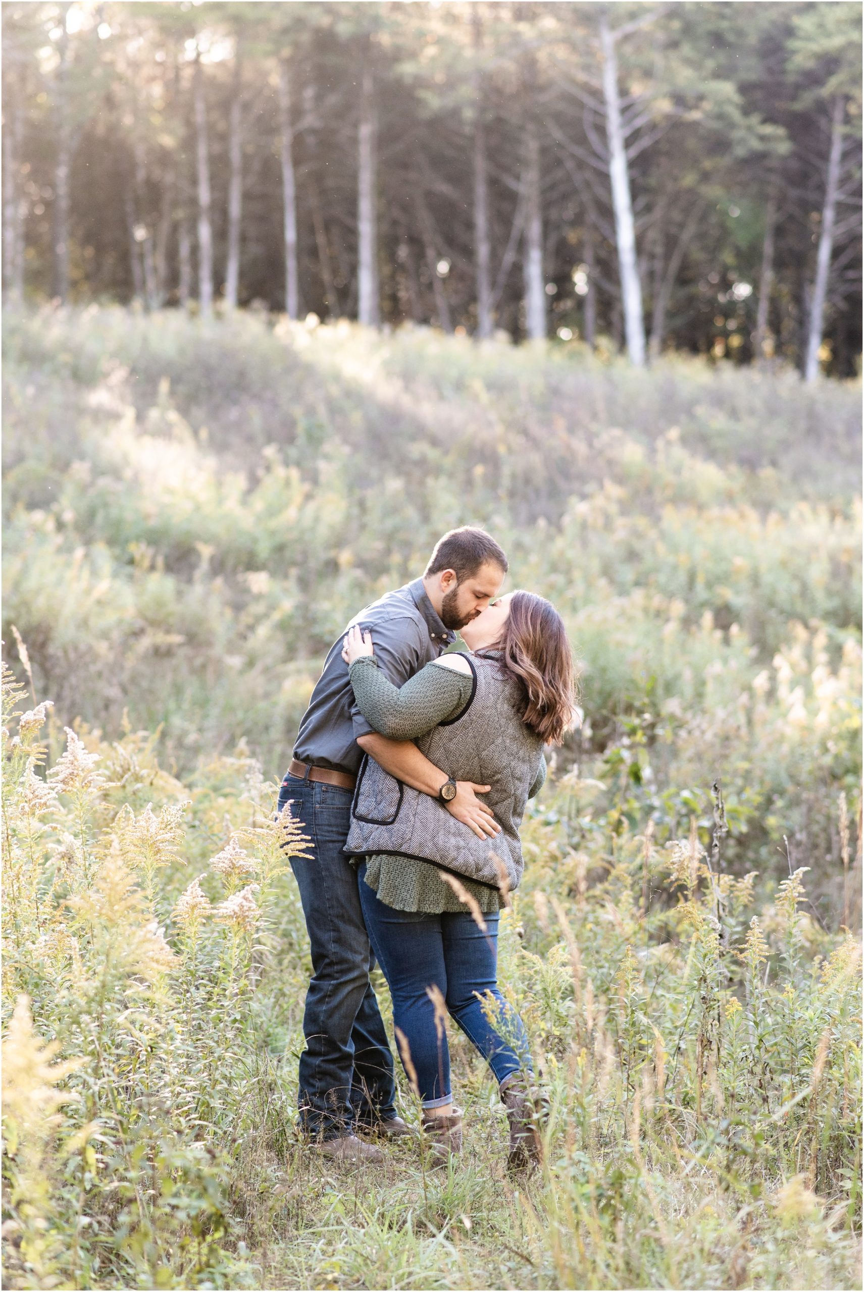 couple kissing in tall grass and sunlight for runge nature center engagement session