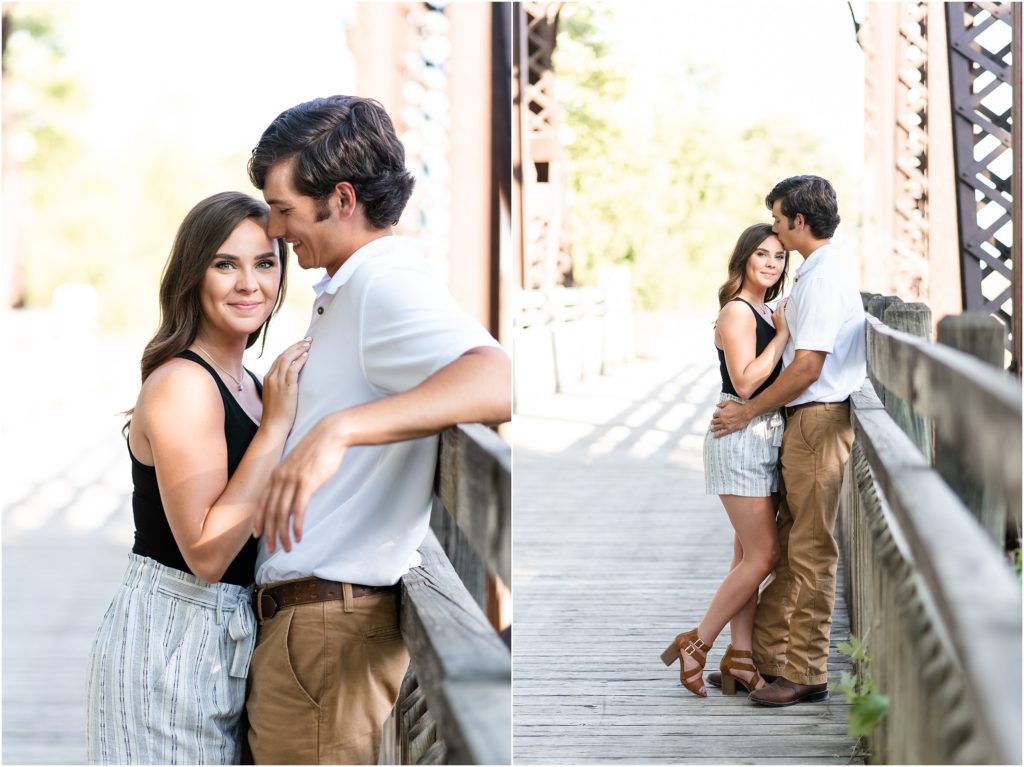 couple on bridge posing for engagement photos