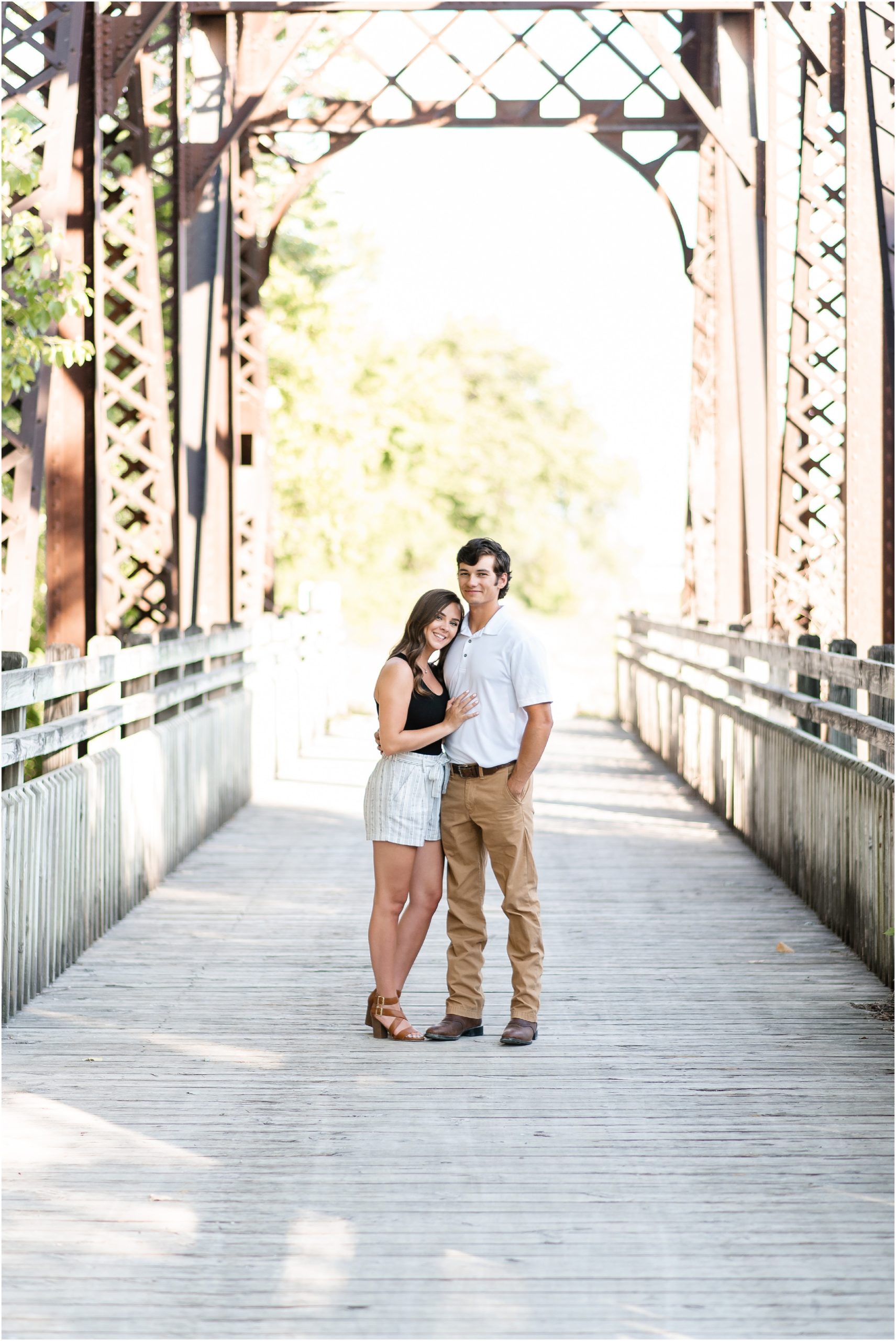 couple standing on katy trail bridge for engagement photos