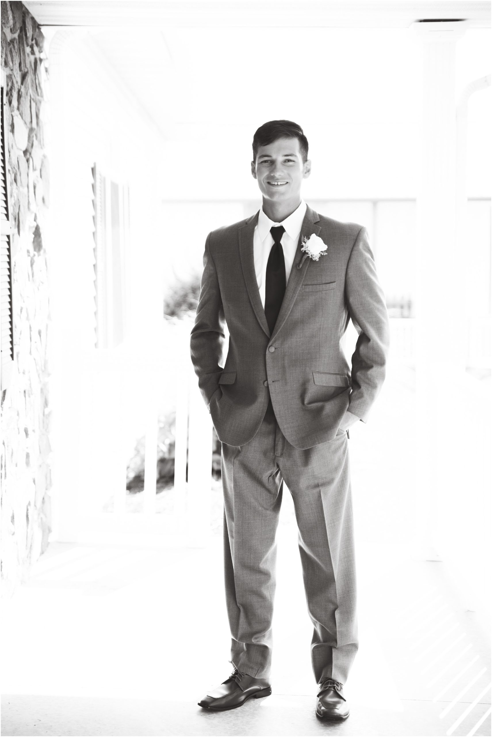 black and white portrait of groom on porch