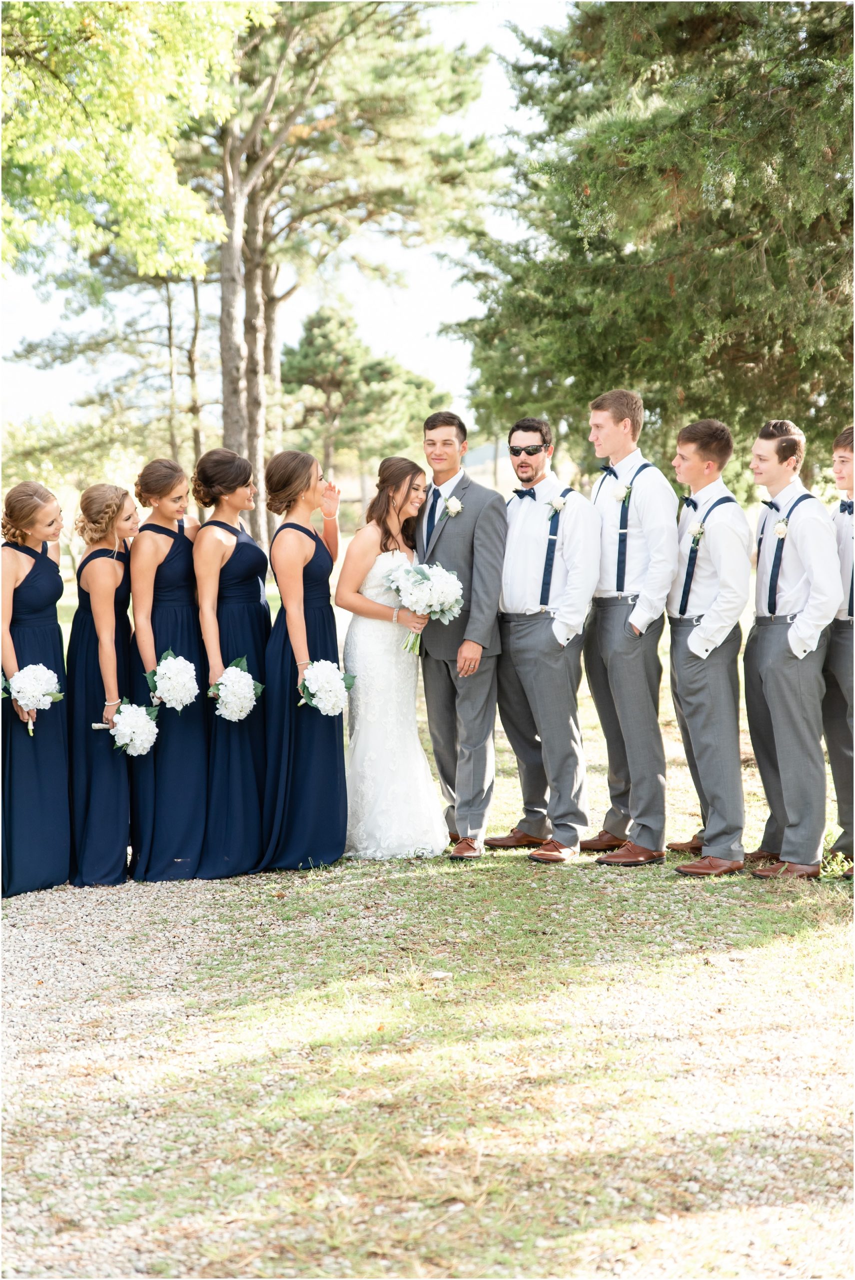 bride and groom laughing with wedding party