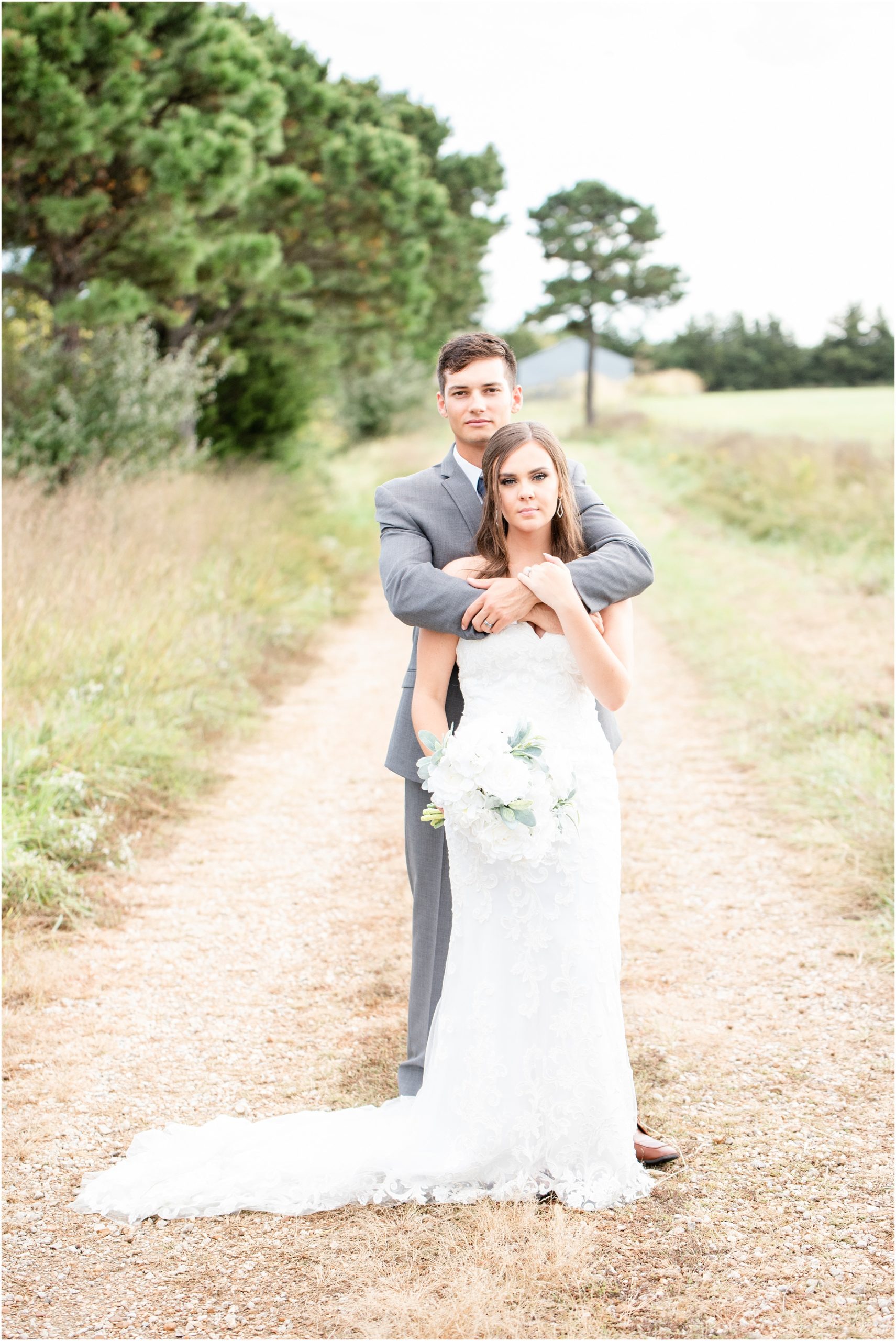 bride and groom portrait down tree lined path for linn, mo wedding