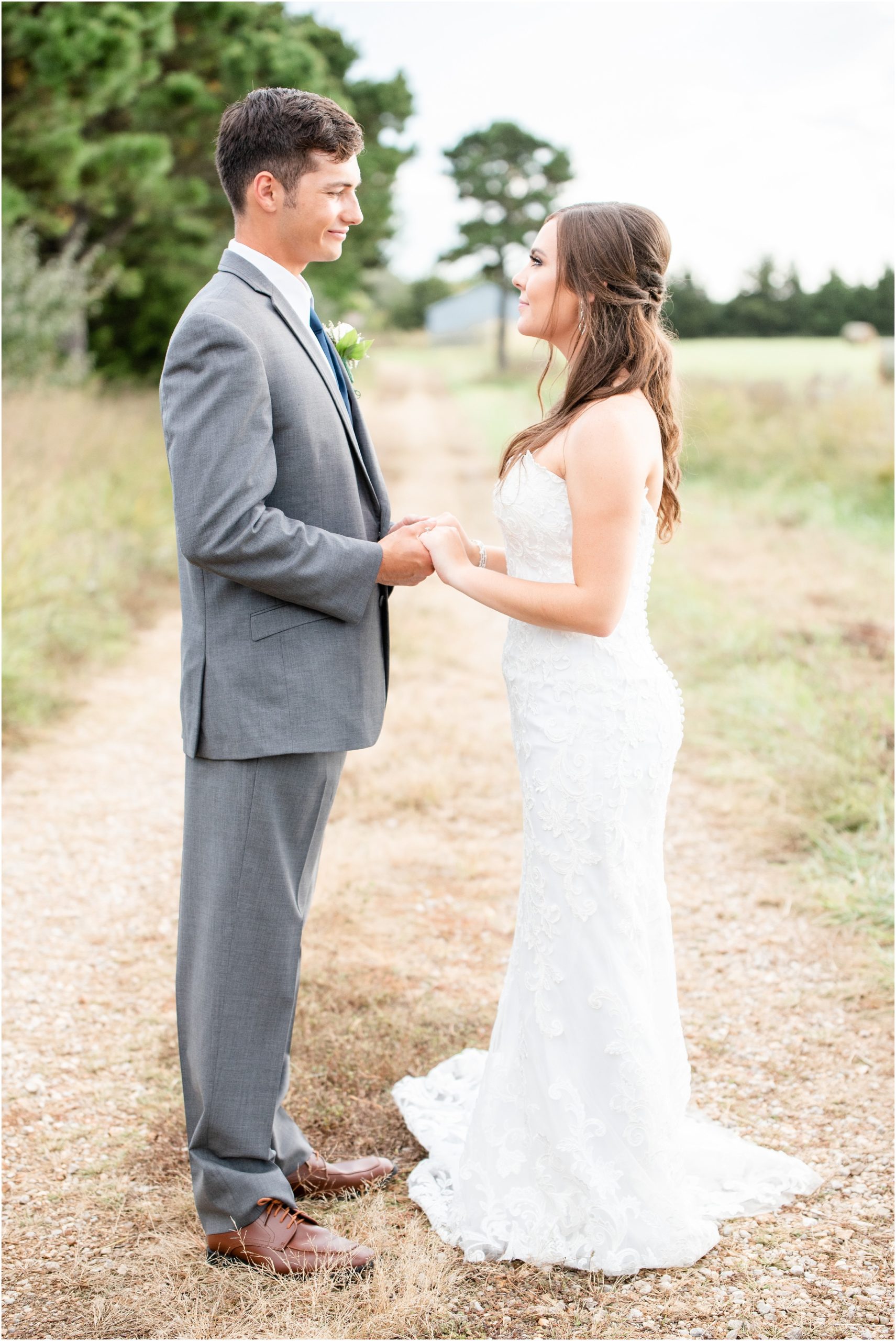 bride and groom holding hands on path for portraits