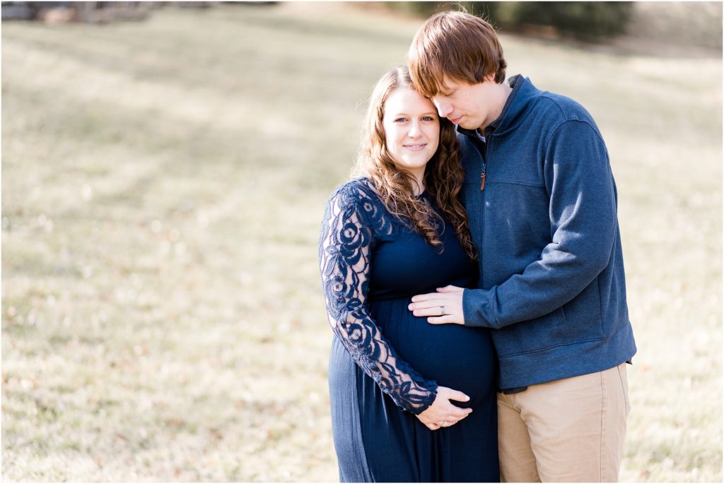 maternity session for couple in navy husband touching belly