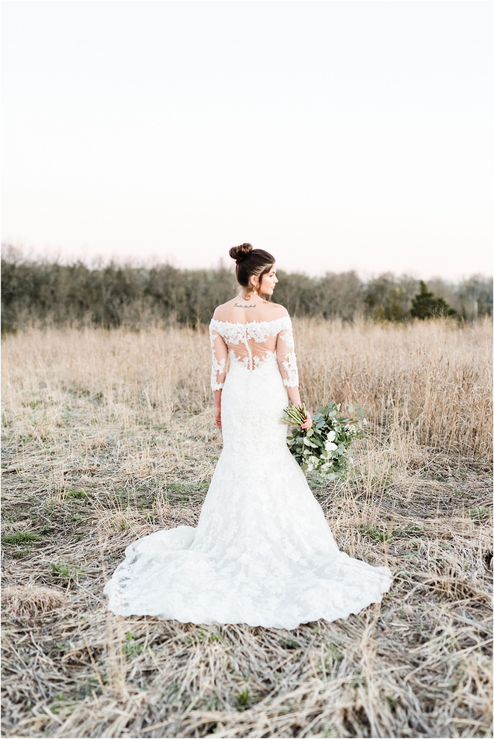 bridal session portrait of back of wedding dress in field