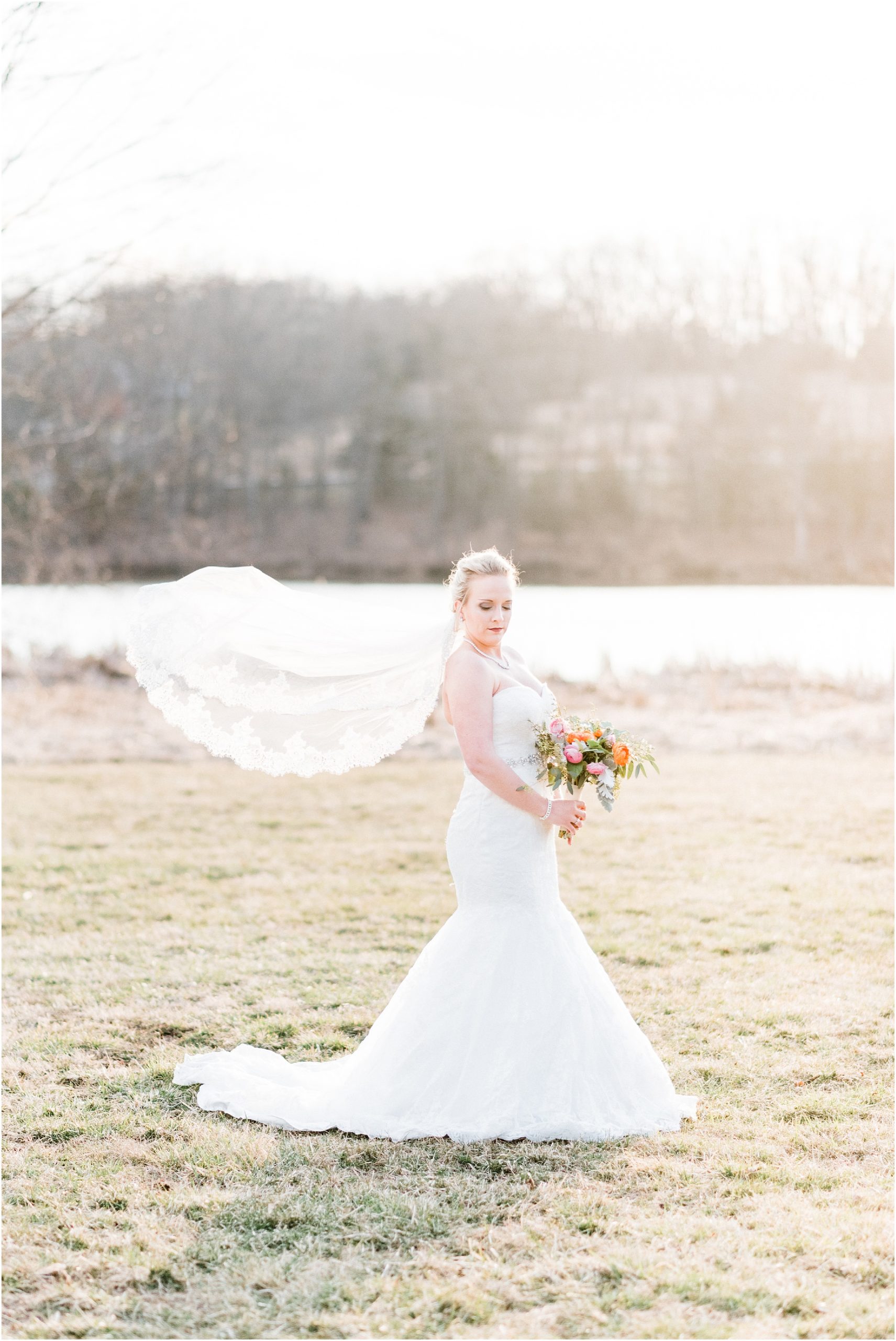 bridal portrait in sunset with veil flying and peach and coral bridal bouquet