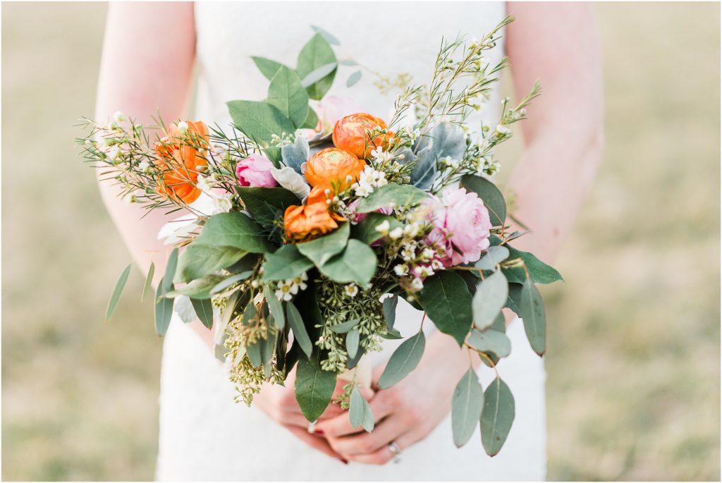 detail shot of peach and coral bouquet with greenery during bridal session