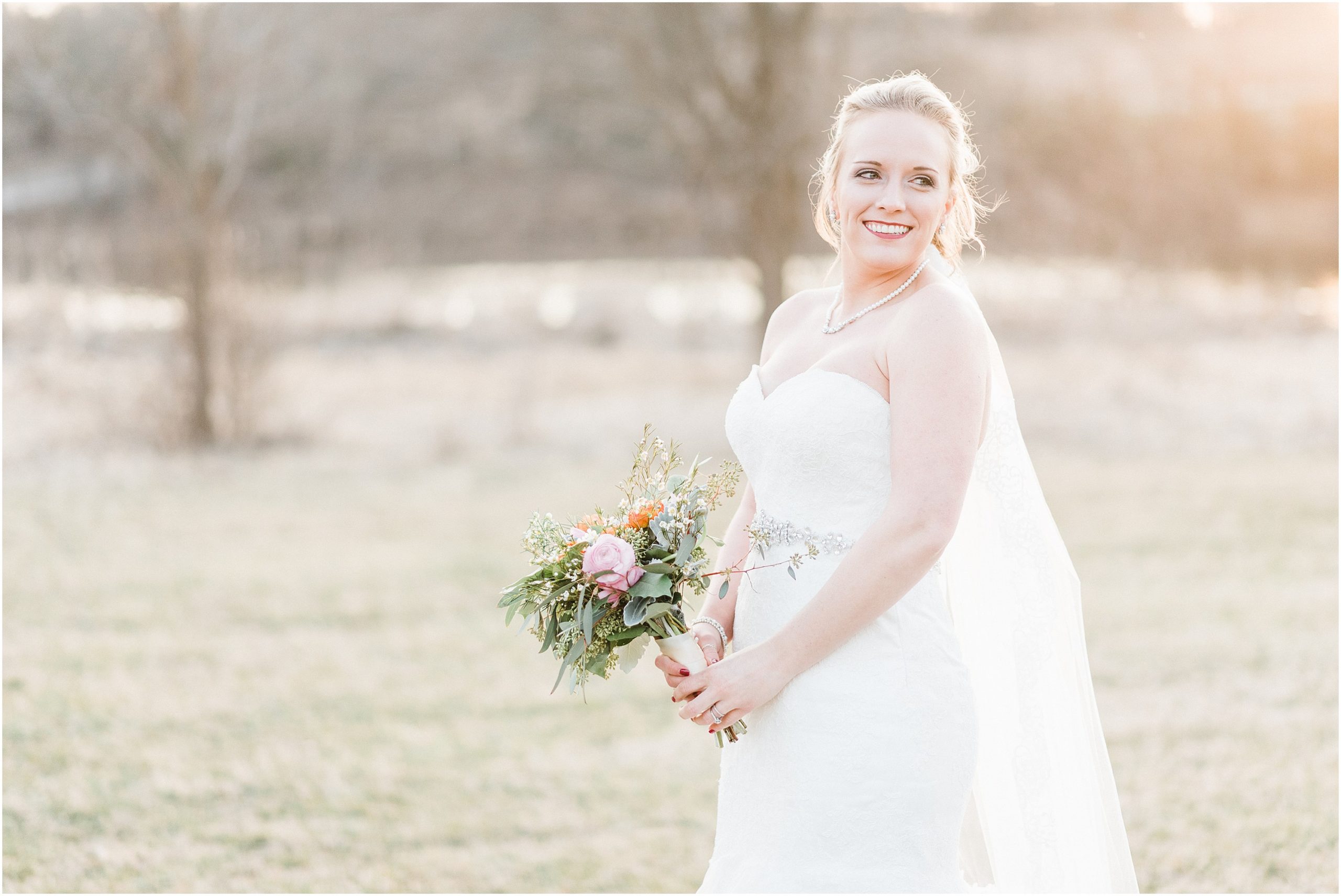 bride looking over her shoulder with peach and coral bridal bouquet at bridal session