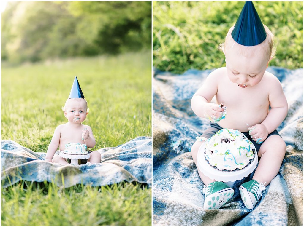 one year old boy eating cake on blanket in grass