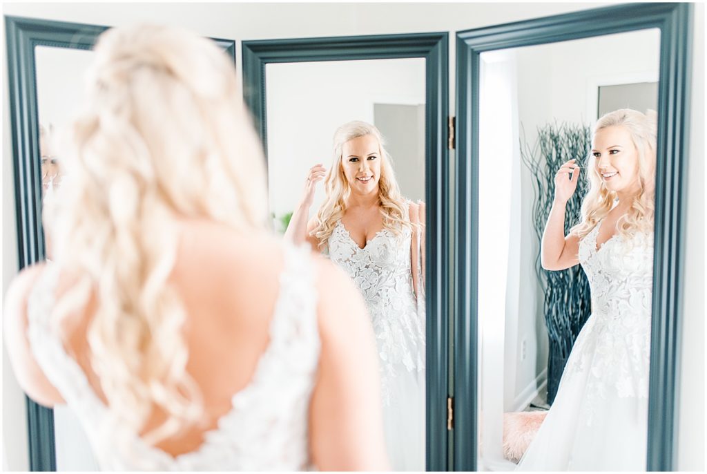 bride fixing hair in mirror