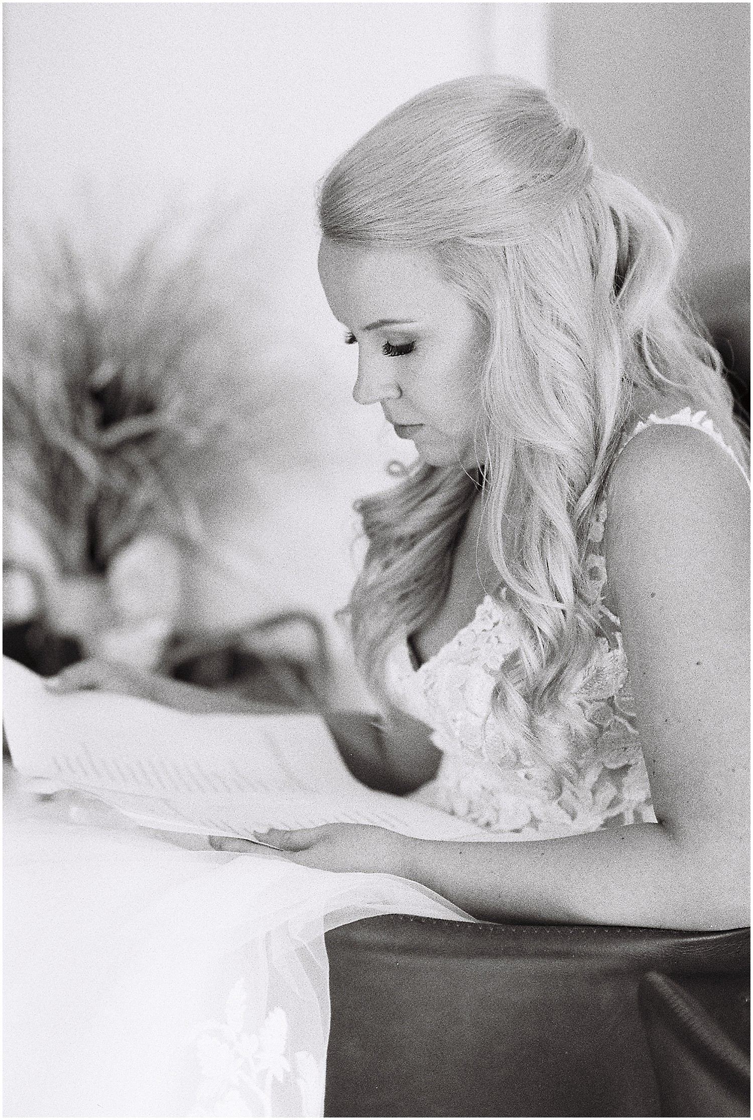 black and white image of bride sitting and reading over her vows