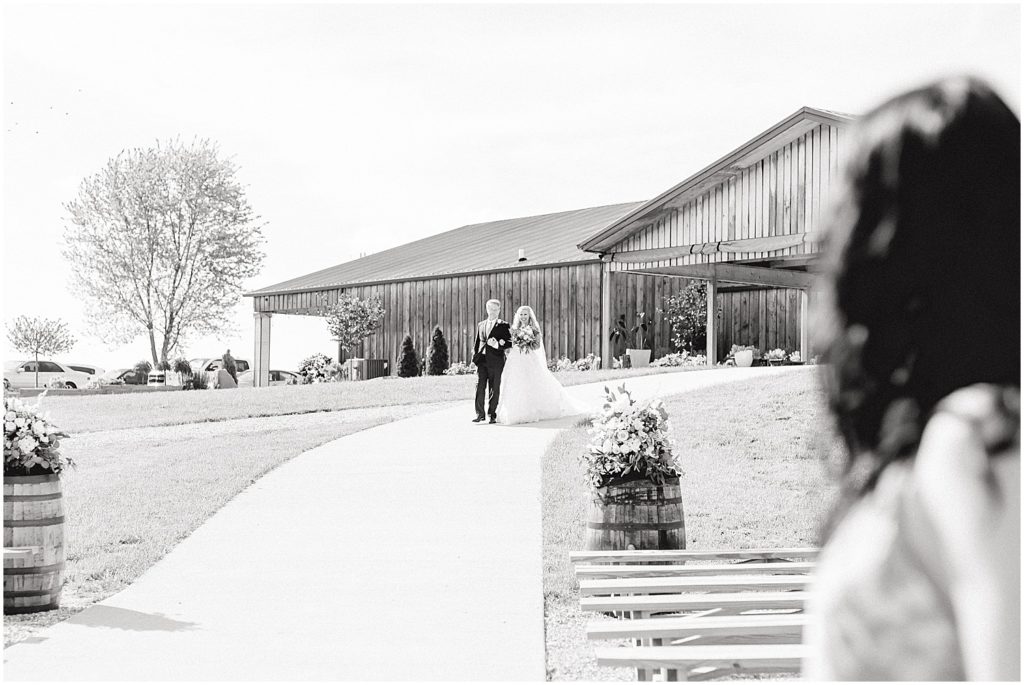black and white image of bride walking down the aisle with her dad