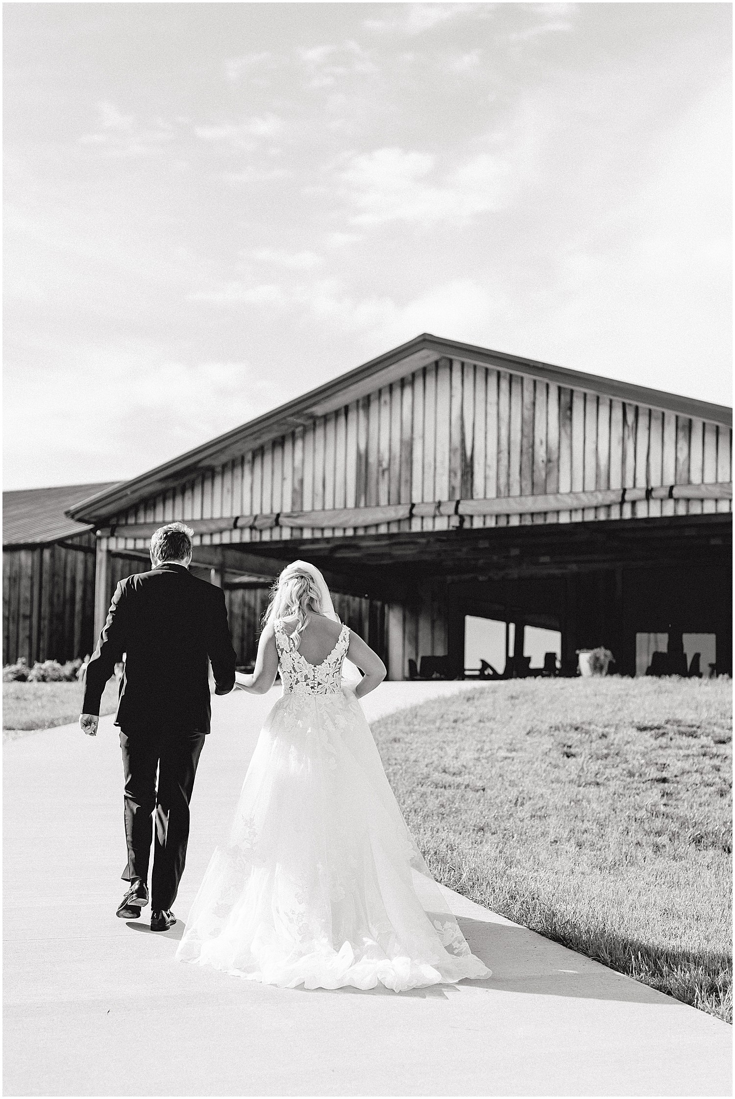 black and white image of bride and groom walking toward cooper's ridge