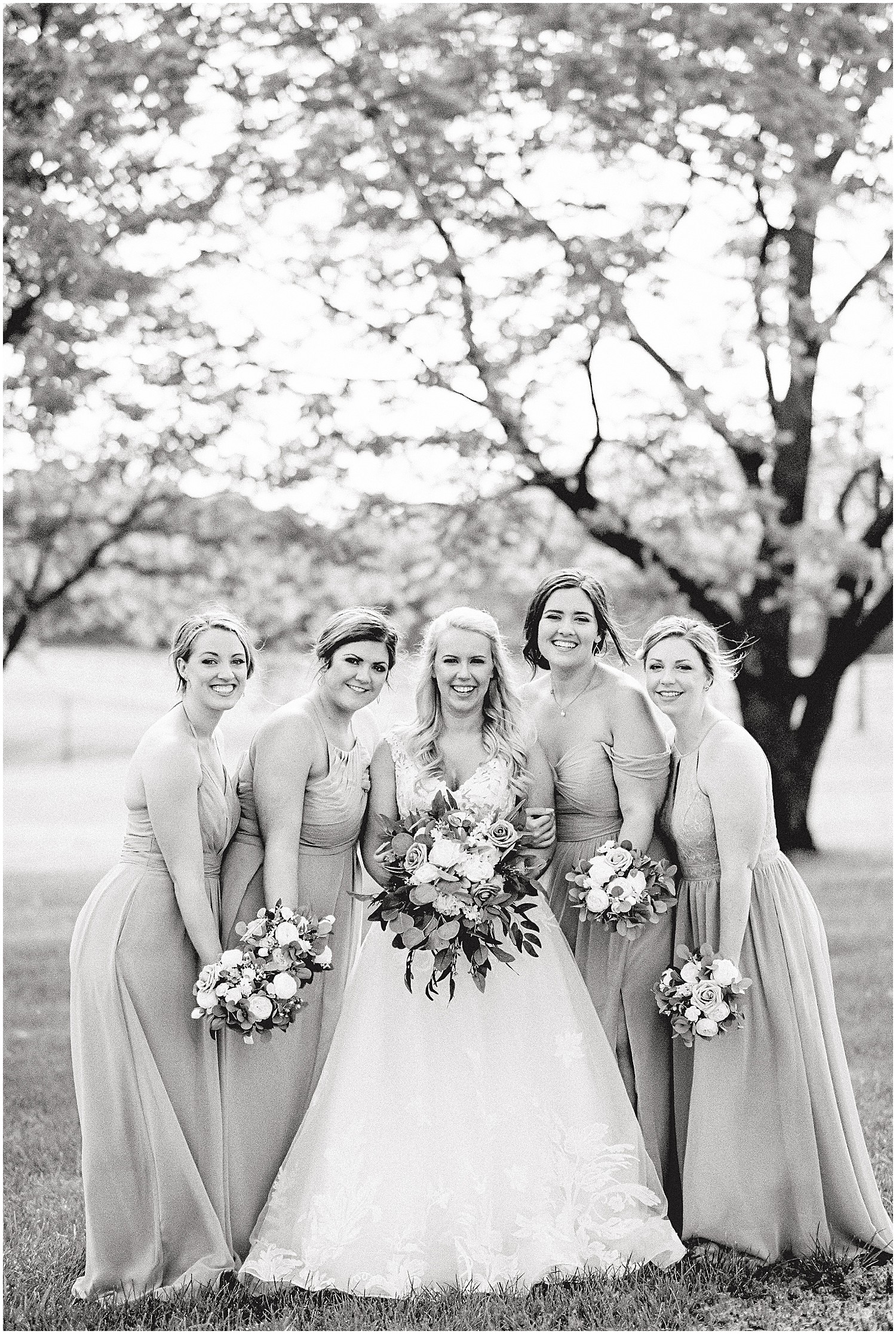 black and white image of bride standing with bridesmaids