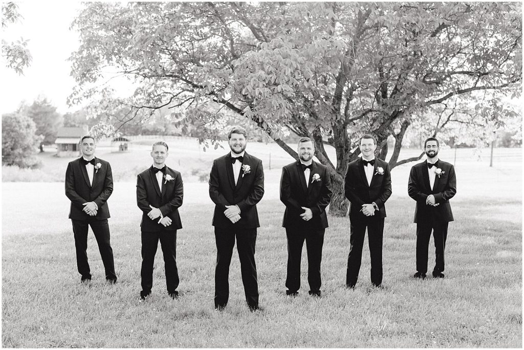black and white image of groom standing with groomsmen