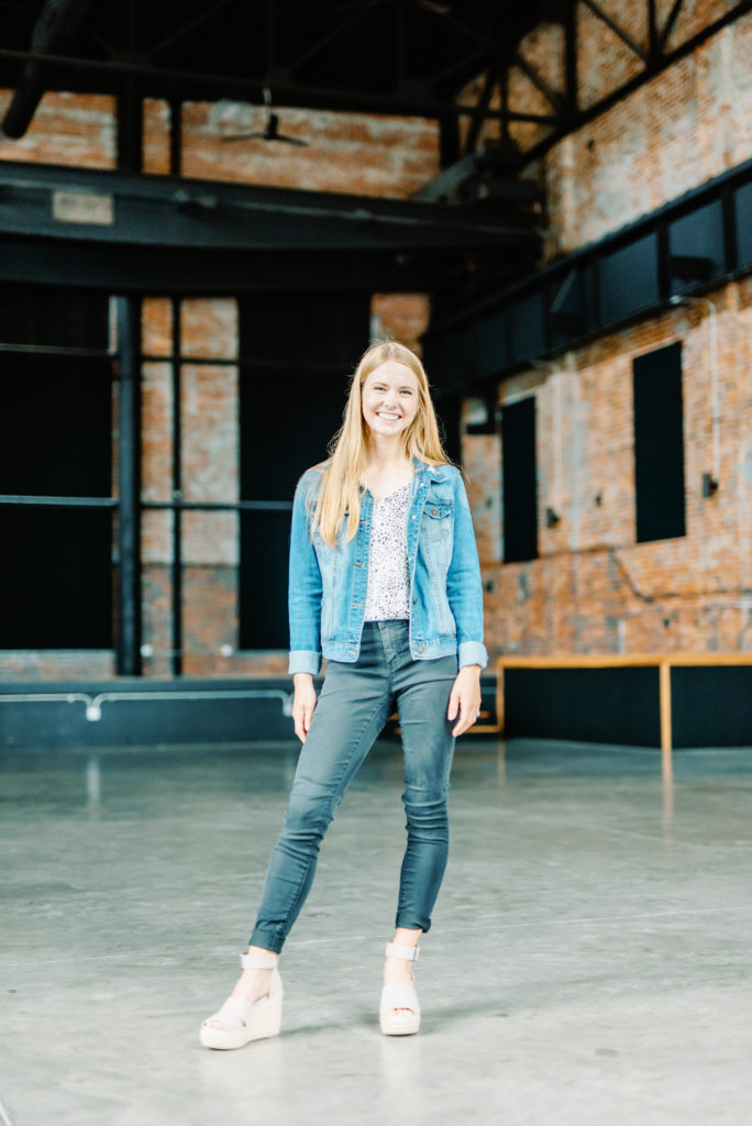 woman standing in empty wedding venue on concrete floors and brick walls millbottom event venue
