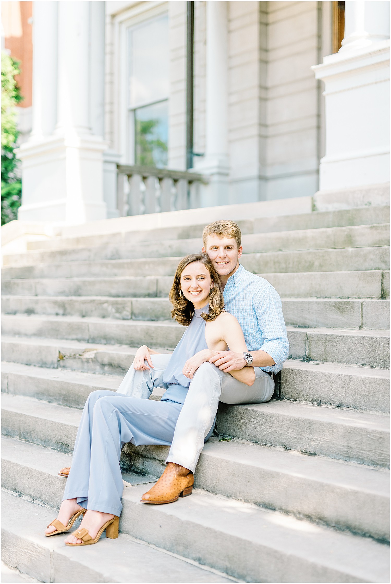 couple sits on concrete stairs on mizzou campus for engagement pictures