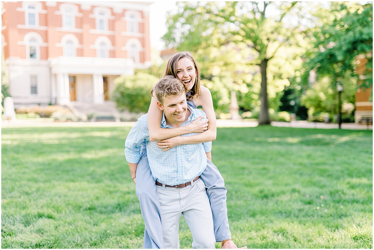 engaged couple piggy back ride and laughing on lawn on mizzou campus