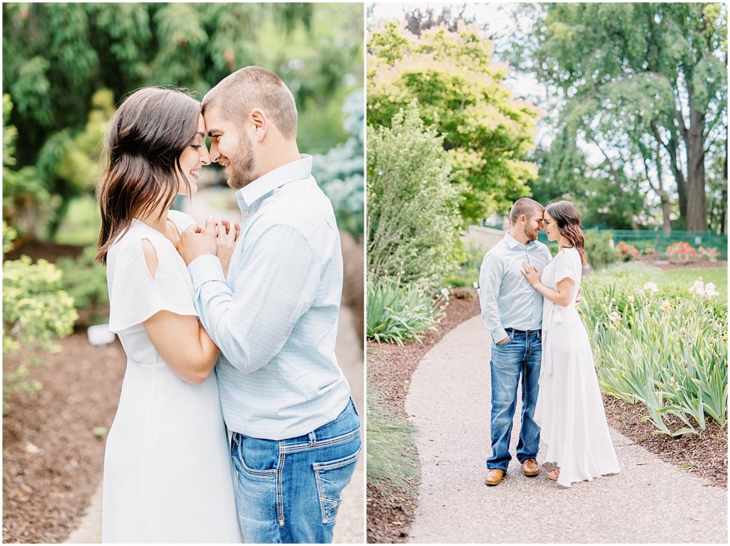 couple holds hands and smiles at each other during city park engagement session