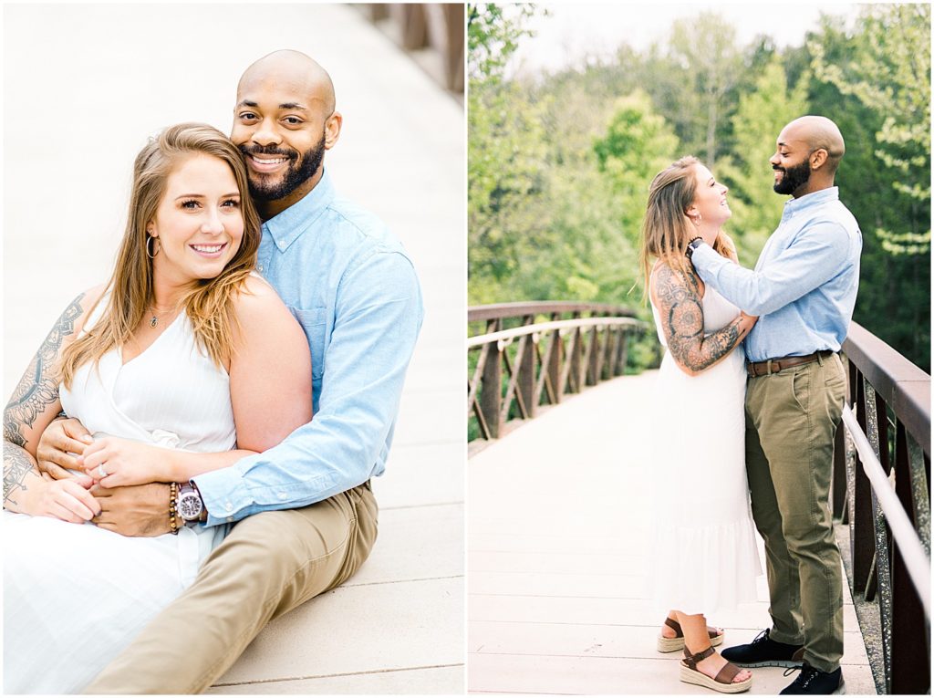 couple sits on bridge and laughs during engagement session