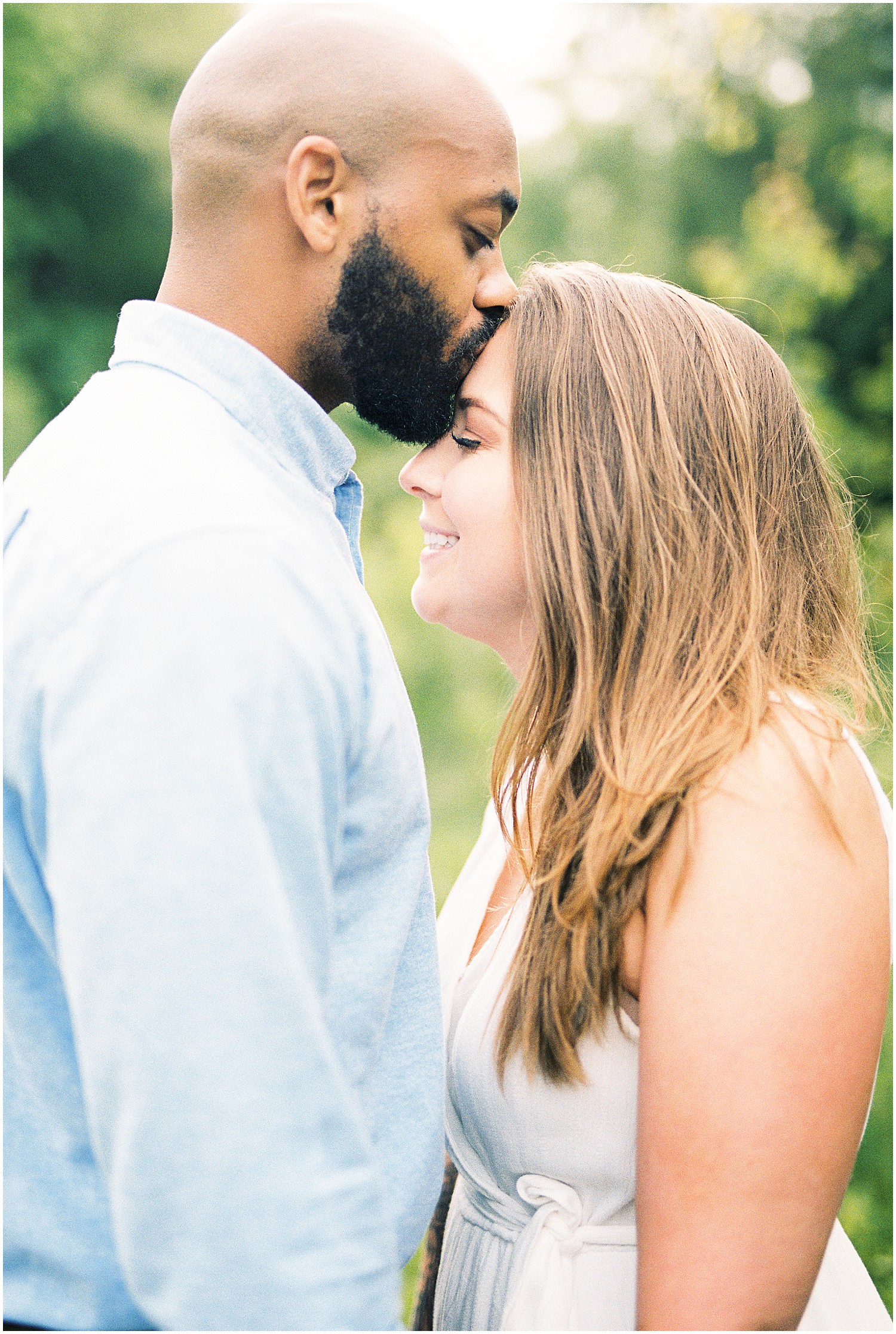 man kisses fiancé's head during photo session on film
