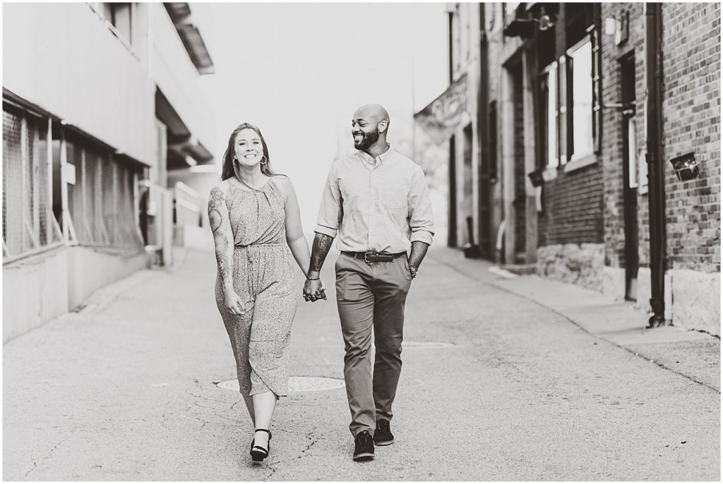black and white image of couple walking in alley way during jefferson city engagement session