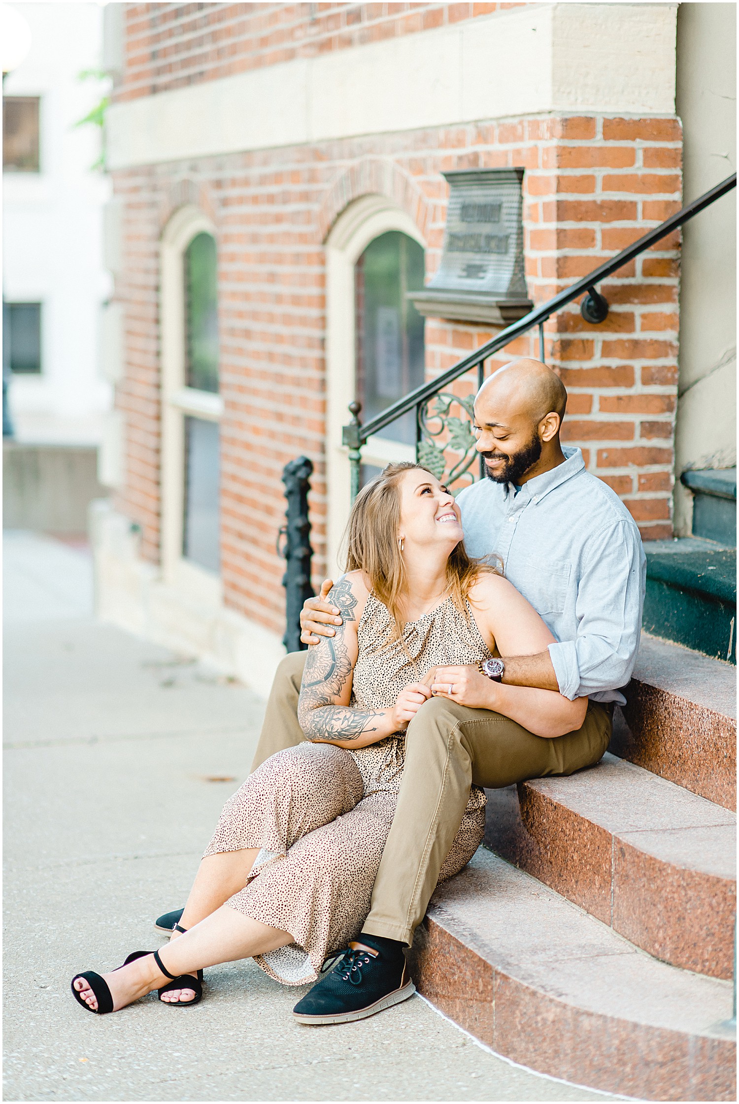 couple sits on staircase and smiles for photos