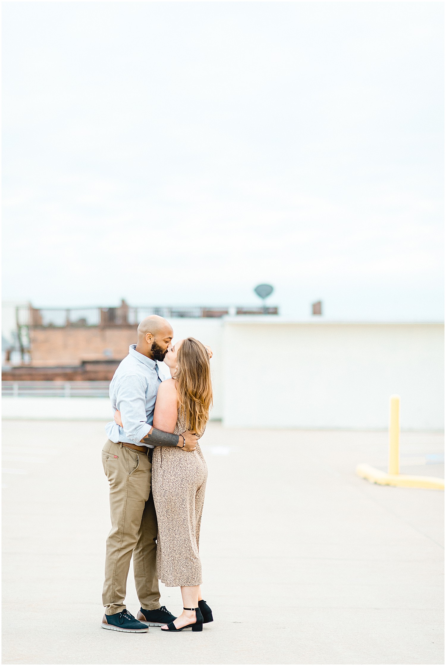 man and fiance dance on top of parking garage for engagement photos in jefferson city, mo