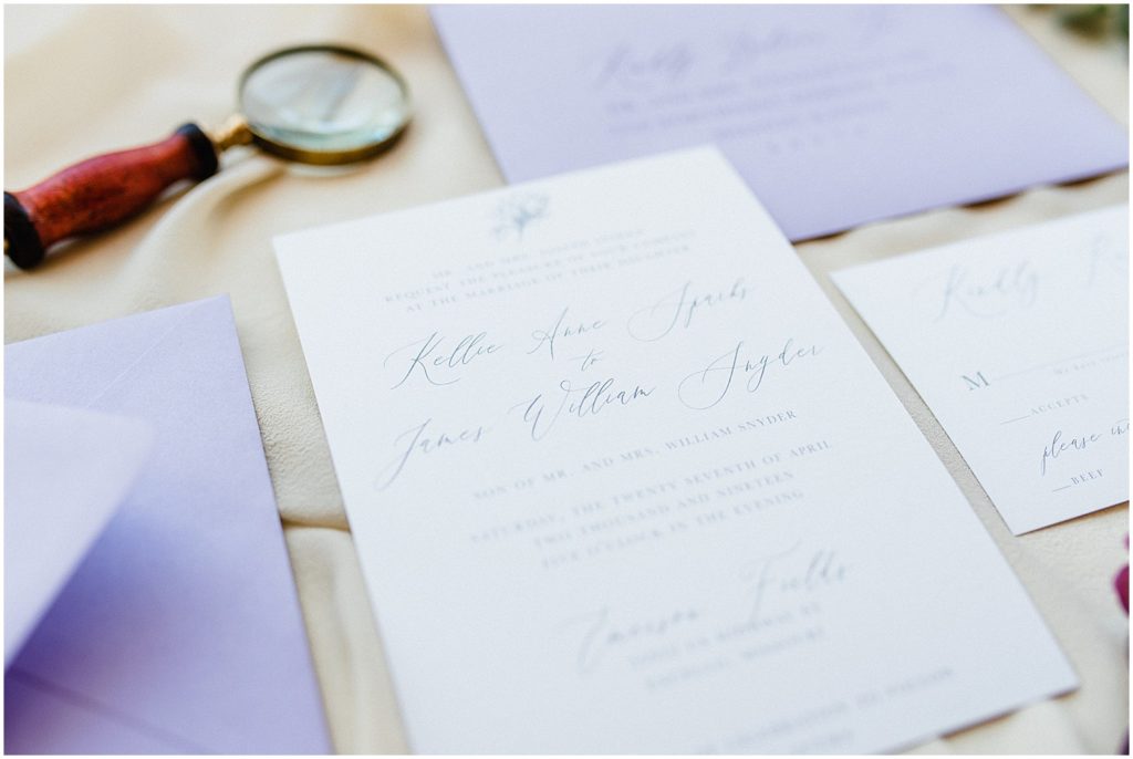 invitation suite featuring calligraphy and purple envelopes