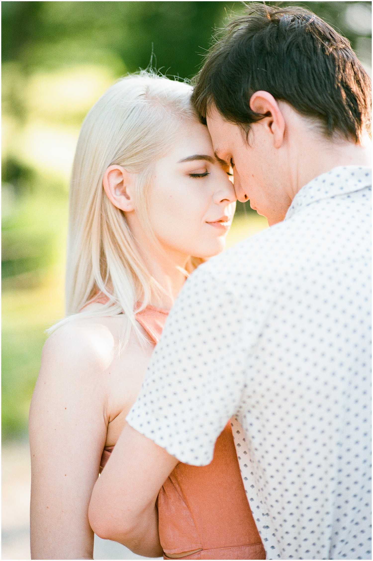 young couple stand forehead to forehead with eyes closed during engagement session at kempkers back 40