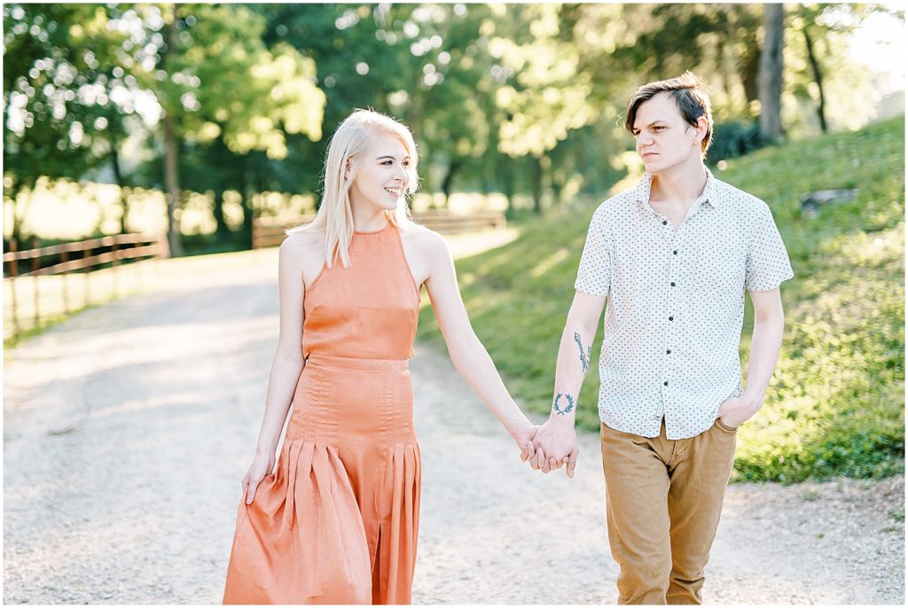a young couple walks hand in hand for missouri engagement session