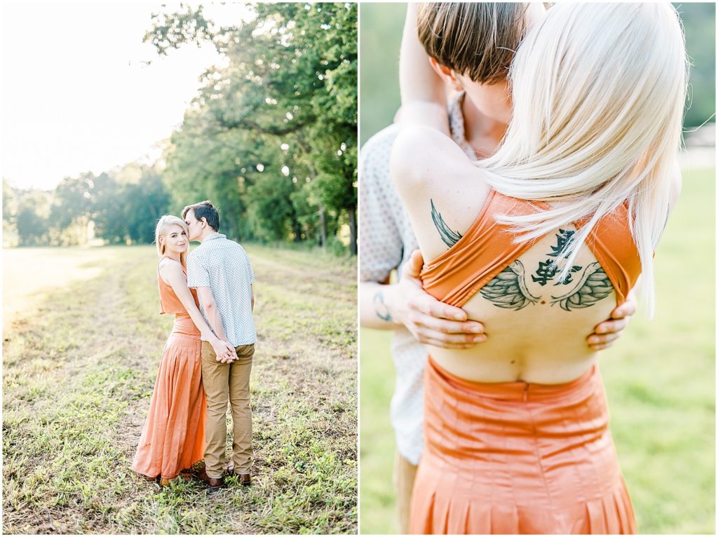 young couple stands in a field and hugs showing tattoos for engagement pictures