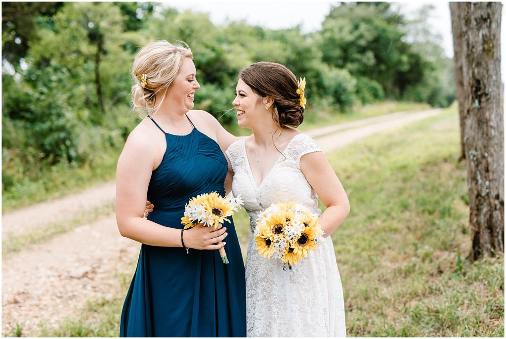 bride and her sister smile at each other on wedding day