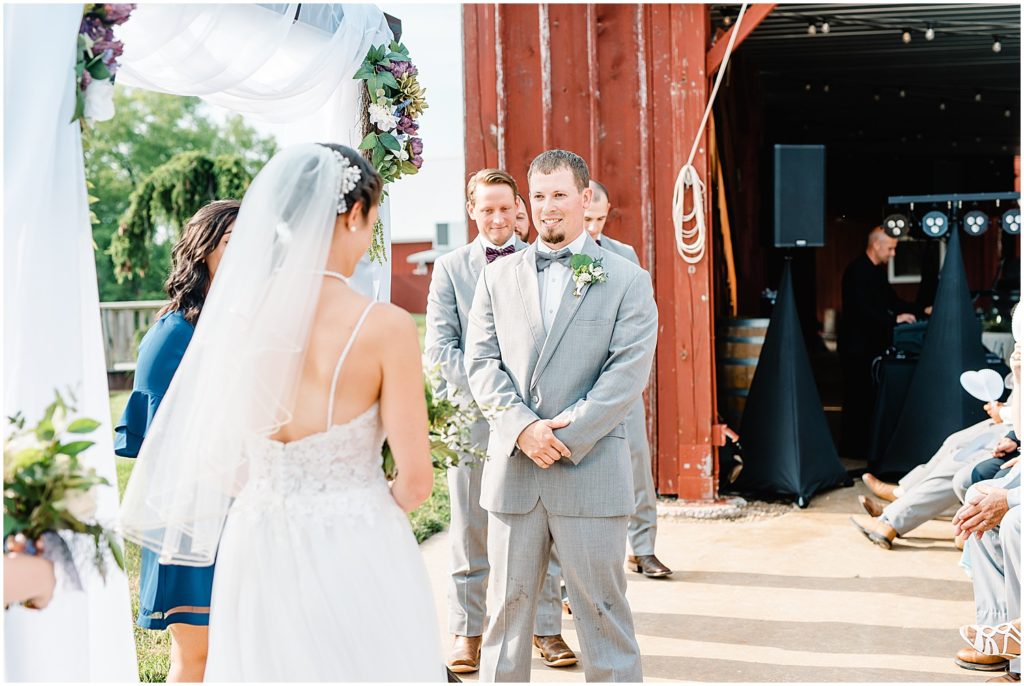 a groom stares at his bride at the altar during wedding ceremony