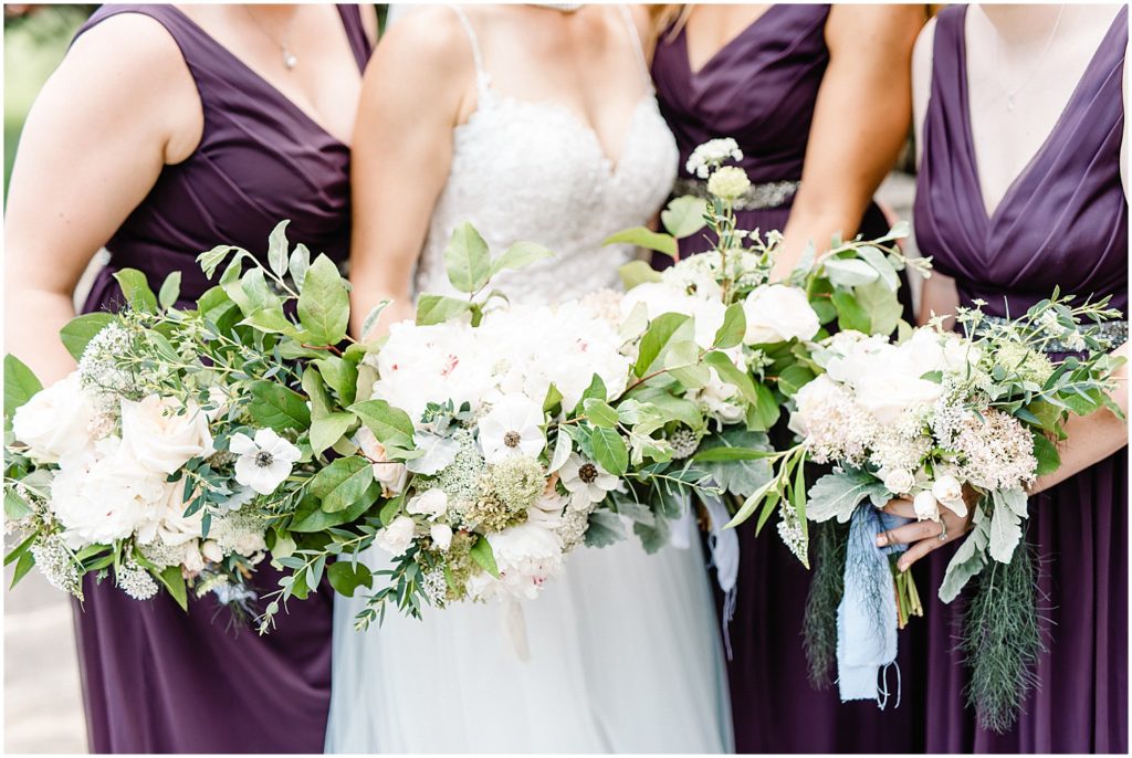 bridesmaids wearing purple holding green and white bouquets