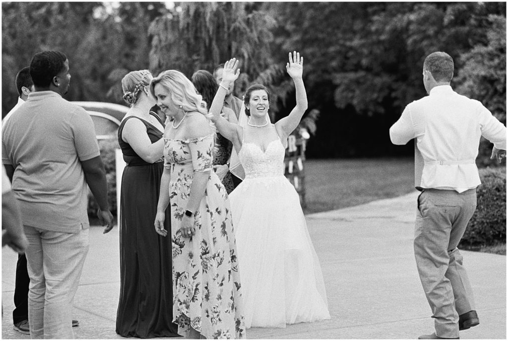 bride raises her hands and dances during wedding reception 