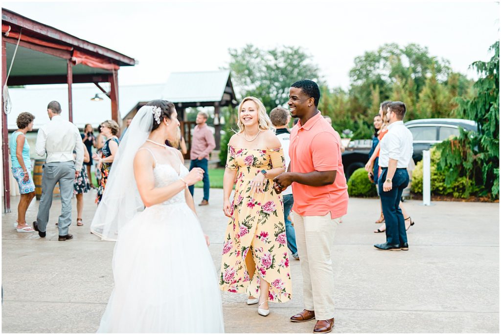 bride dances with wedding guests on patio at cedar lake cellars wedding