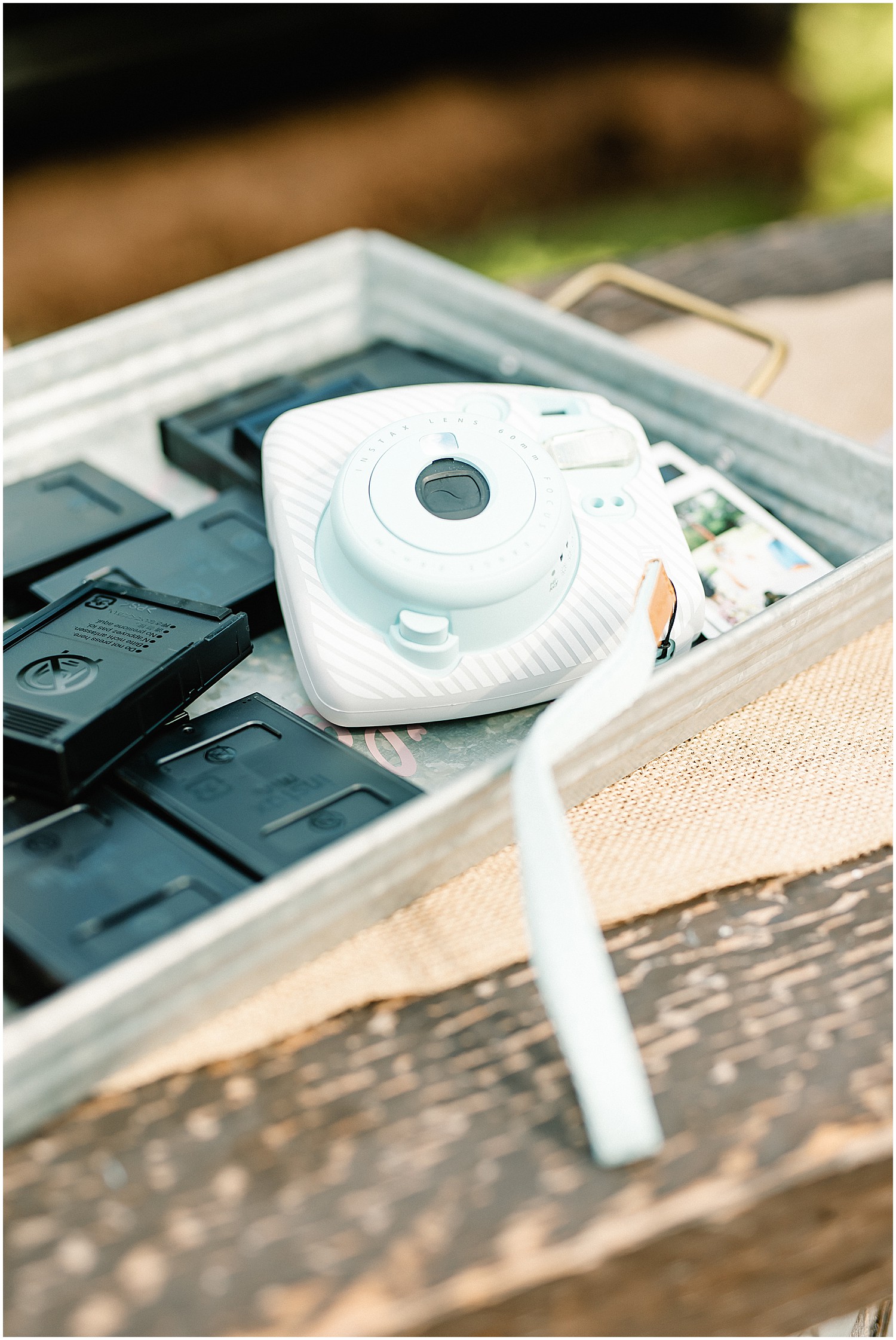 an instant camera rests in a metal tray for guests to use at wedding reception