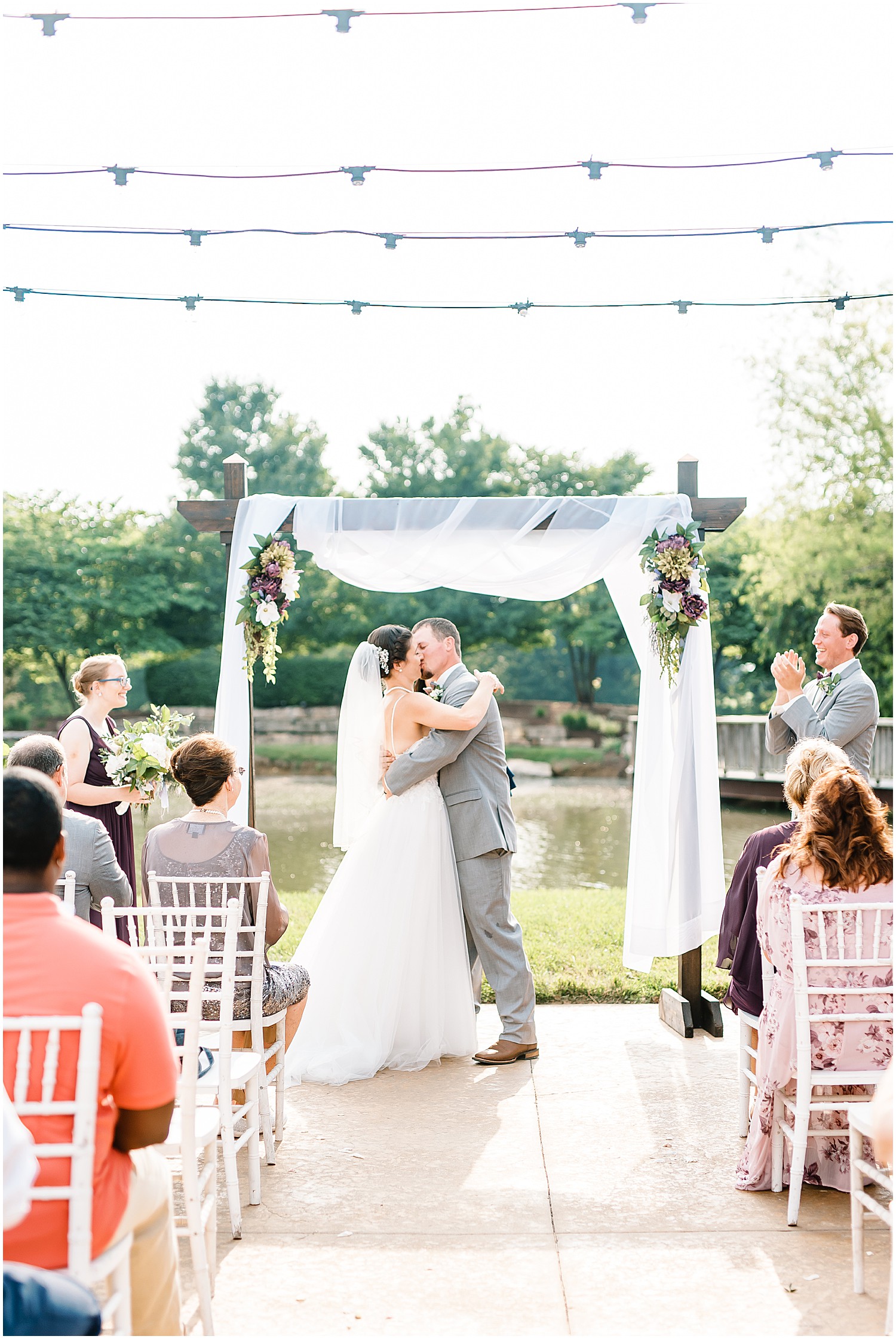 bride and groom first kiss during outdoor wedding ceremony at cedar lake cellars