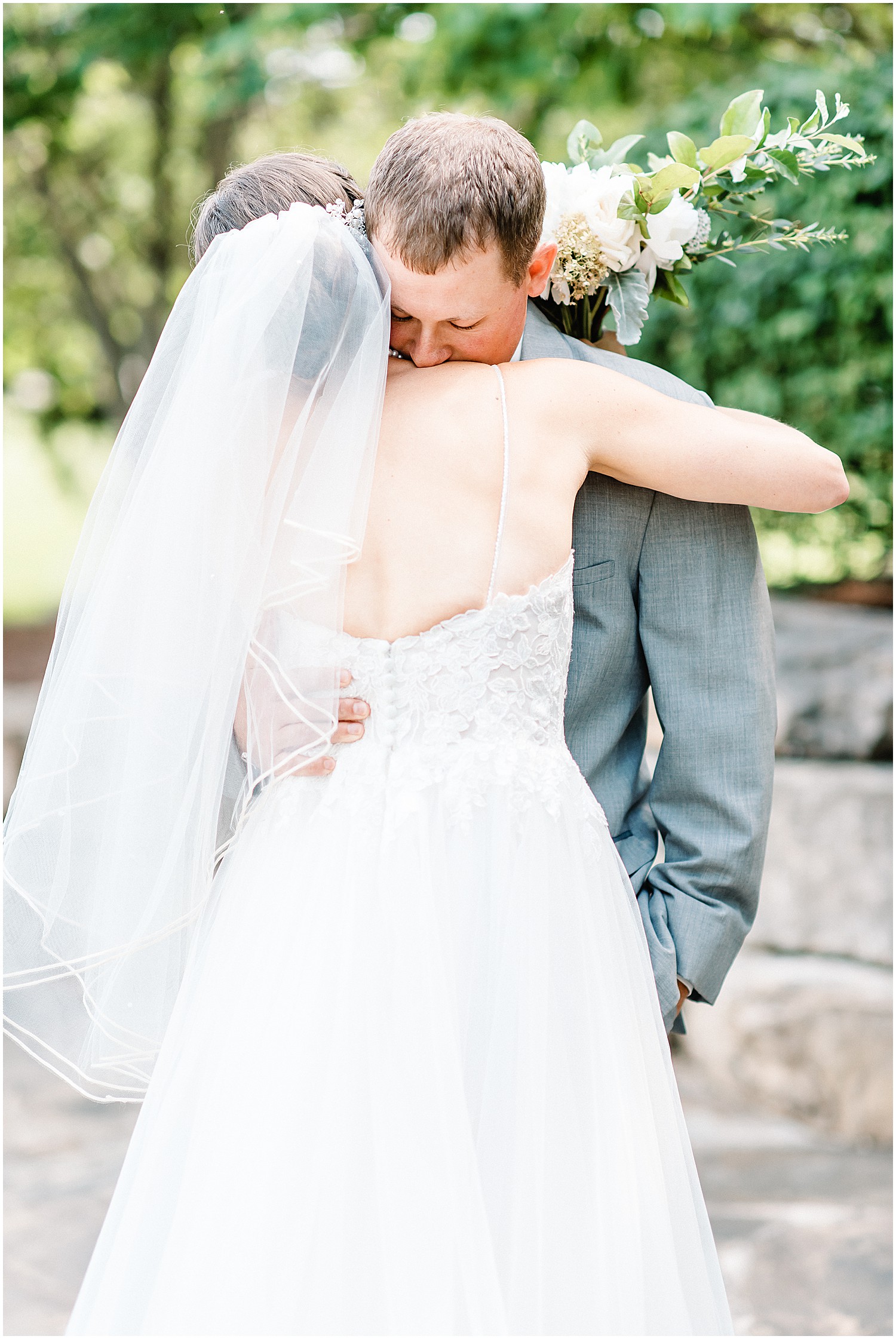 bride and groom hug after a first look at cedar lake cellars wedding in wright city, mo